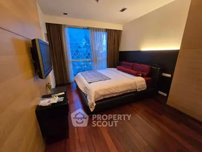 Luxurious bedroom with modern design and city view, featuring hardwood floors and elegant furnishings.