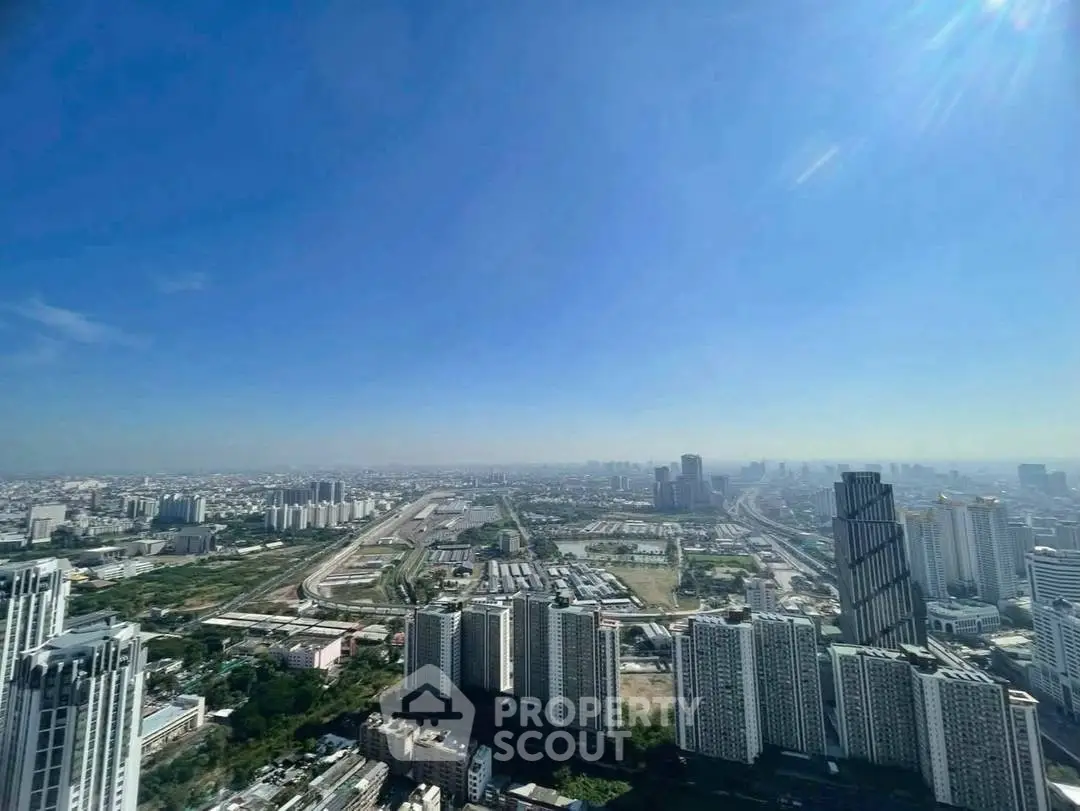 Stunning panoramic cityscape view from a high-rise building, showcasing urban skyline and clear blue sky.