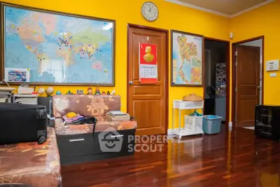 Vibrant living room with world maps and wooden flooring, ideal for travel enthusiasts.