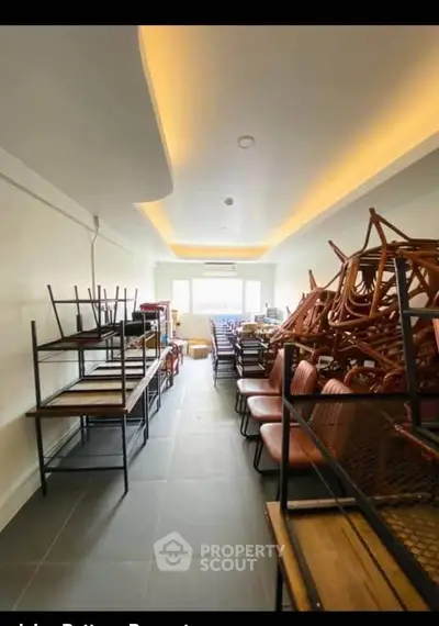 Spacious storage room with stacked chairs and shelves, ideal for organizing and maximizing space.