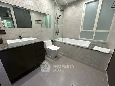 Modern bathroom with sleek design, featuring a bathtub and stylish fixtures.