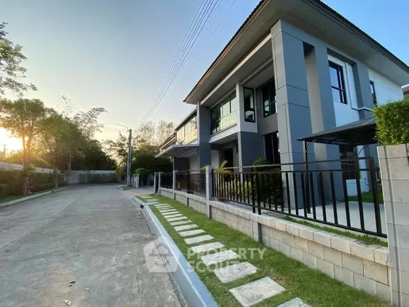Modern two-story house with sleek design and spacious driveway in serene neighborhood.