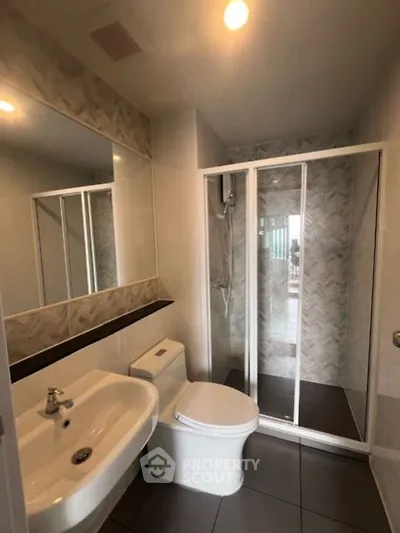 Modern bathroom with glass shower and stylish sink in a contemporary apartment.