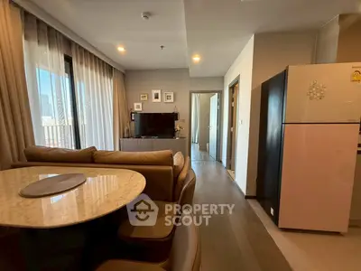 Modern open-plan living room with dining area and stylish kitchen in a cozy apartment.