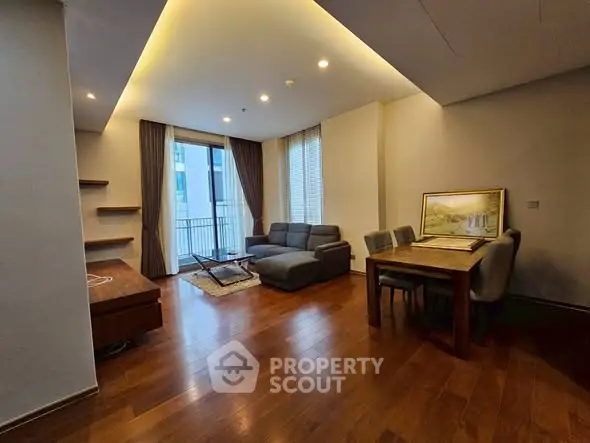 Spacious living room with modern furniture and balcony access in a stylish apartment.