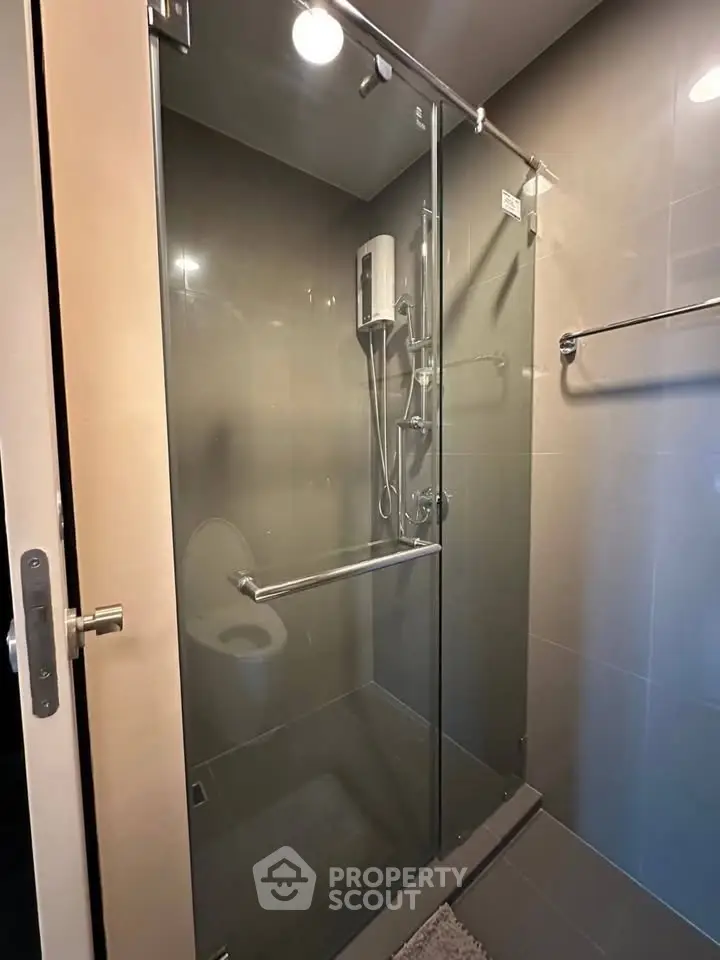 Modern bathroom with glass shower enclosure and sleek fixtures, perfect for a contemporary home.