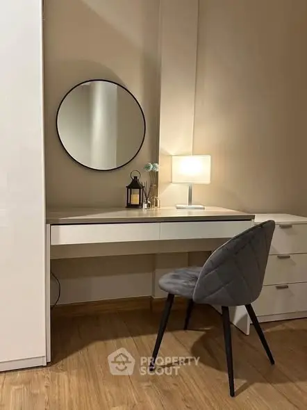 Stylish study nook with modern desk, chair, and round mirror in cozy apartment.