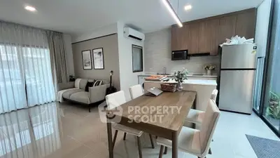 Modern open-plan living and dining area with sleek kitchen and stylish decor.