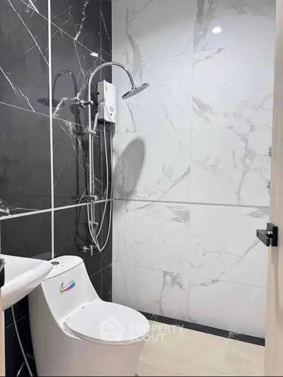 Modern bathroom with sleek black and white marble tiles and contemporary fixtures.