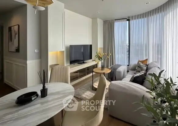 Modern living room with stylish furniture and large windows offering natural light.