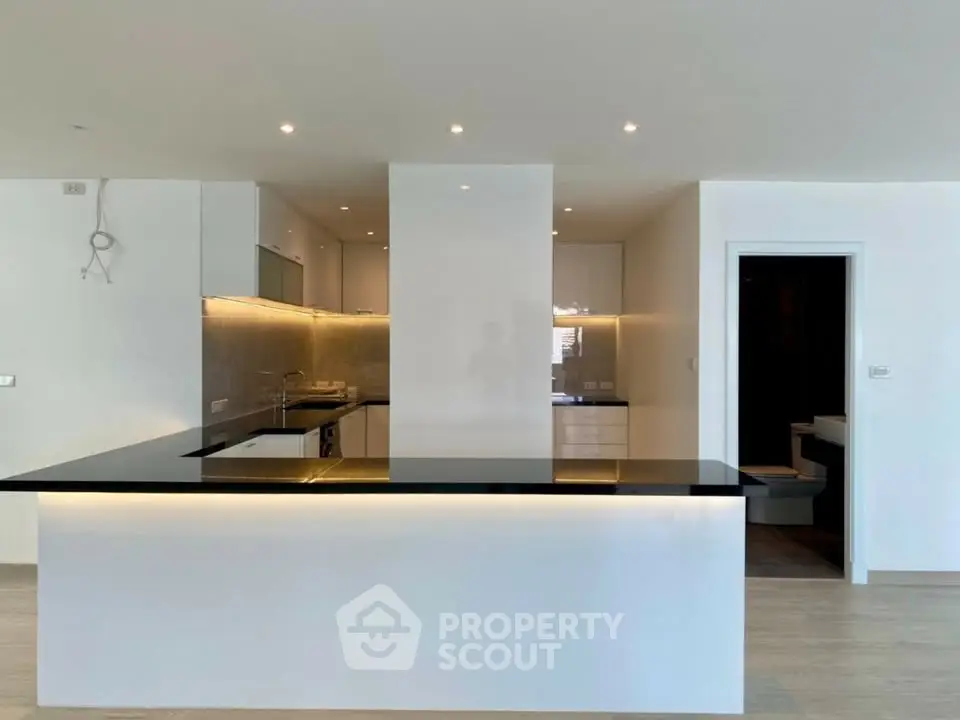 Modern kitchen with sleek black countertops and ambient lighting