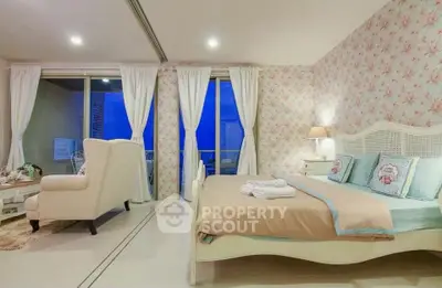 Charming bedroom with floral wallpaper and cozy seating area, featuring a serene ambiance and elegant decor.