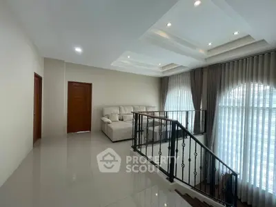 Spacious living room with elegant staircase and cozy seating area, perfect for relaxation and entertaining.