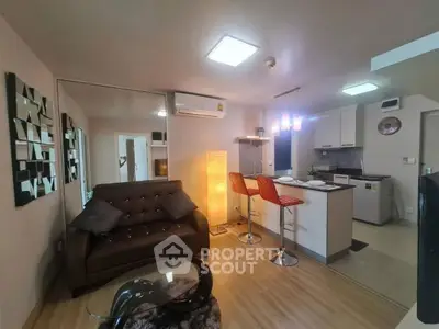 Modern open-layout living room with stylish kitchen and cozy seating area.