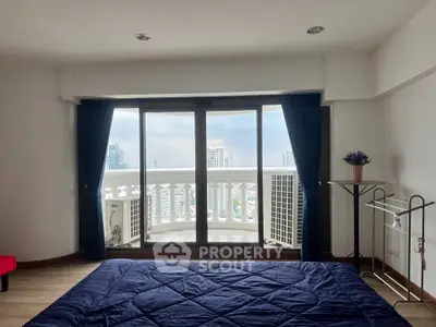 Spacious bedroom with city view and balcony access in modern apartment