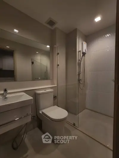 Modern bathroom with glass shower and sleek fixtures in contemporary apartment