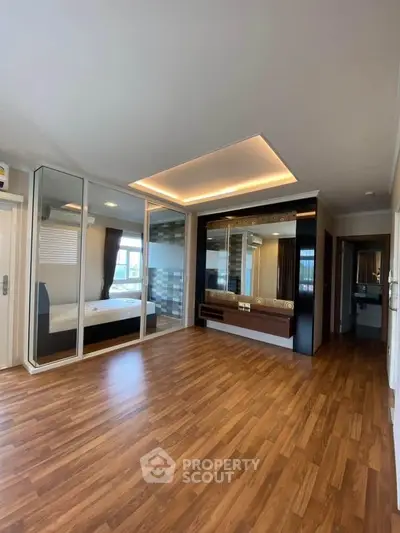 Spacious modern living room with wooden flooring and stylish ceiling lights