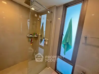 Modern bathroom with glass shower and frosted window for natural light
