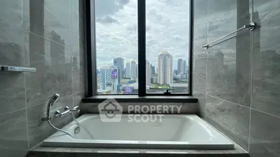 Luxurious bathroom with city view from large window and elegant bathtub.
