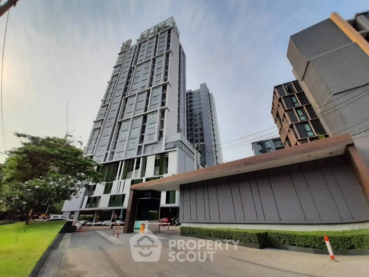 Modern high-rise condominium with sleek design and lush surroundings.
