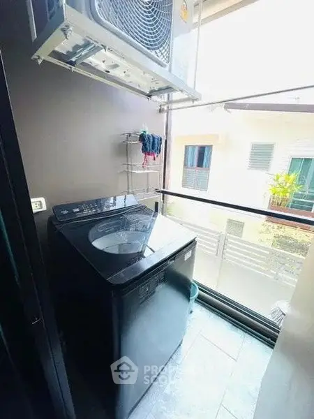 Compact balcony with washing machine and outdoor view in modern apartment