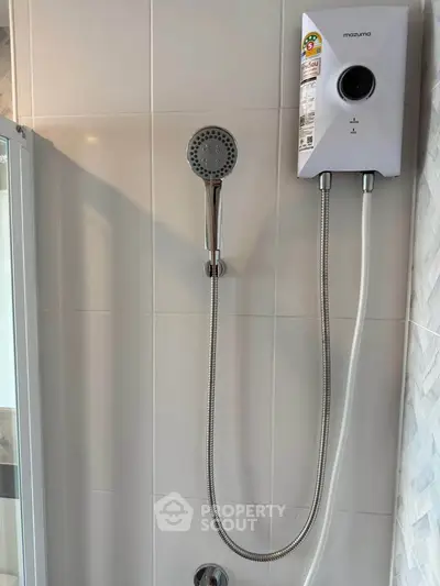 Modern bathroom shower with sleek water heater and handheld showerhead.