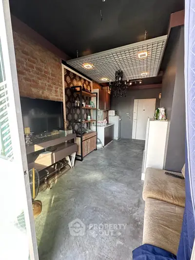 Stylish modern living room with exposed brick wall and sleek furnishings, perfect for urban living.