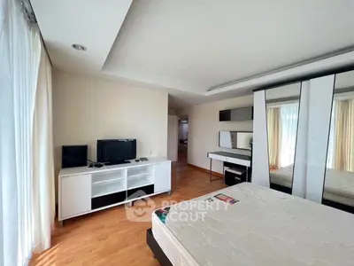 Spacious bedroom with modern furniture and natural light, ideal for comfortable living.