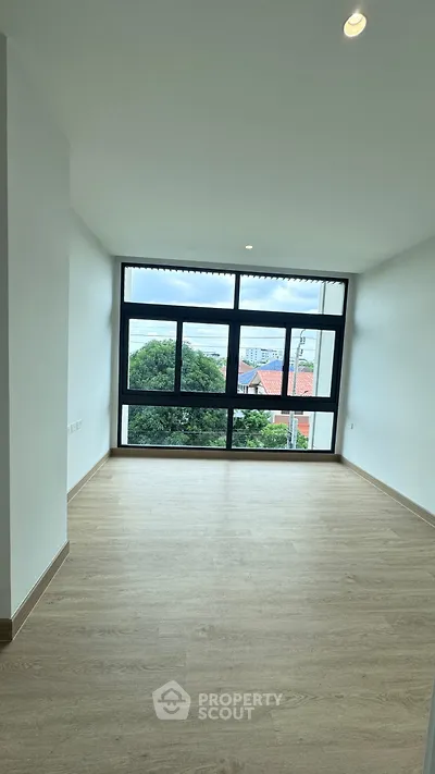 Spacious room with large window offering stunning views and natural light.