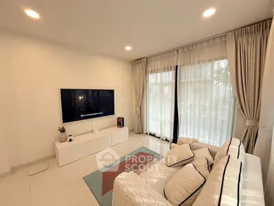 Spacious modern living room with cozy sofa and large TV, perfect for relaxation.