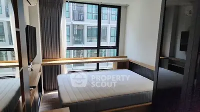 Modern bedroom with large window and natural light in urban apartment