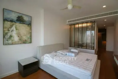 Modern bedroom with stylish decor and large window for natural light.