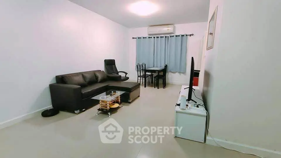 Spacious living room with modern furniture and air conditioning, perfect for relaxation and entertainment.