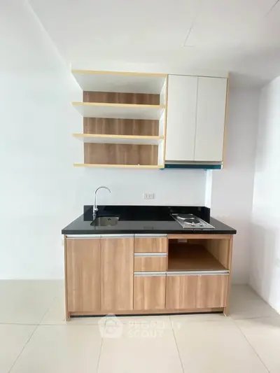 Modern minimalist kitchen with sleek cabinetry and black countertop