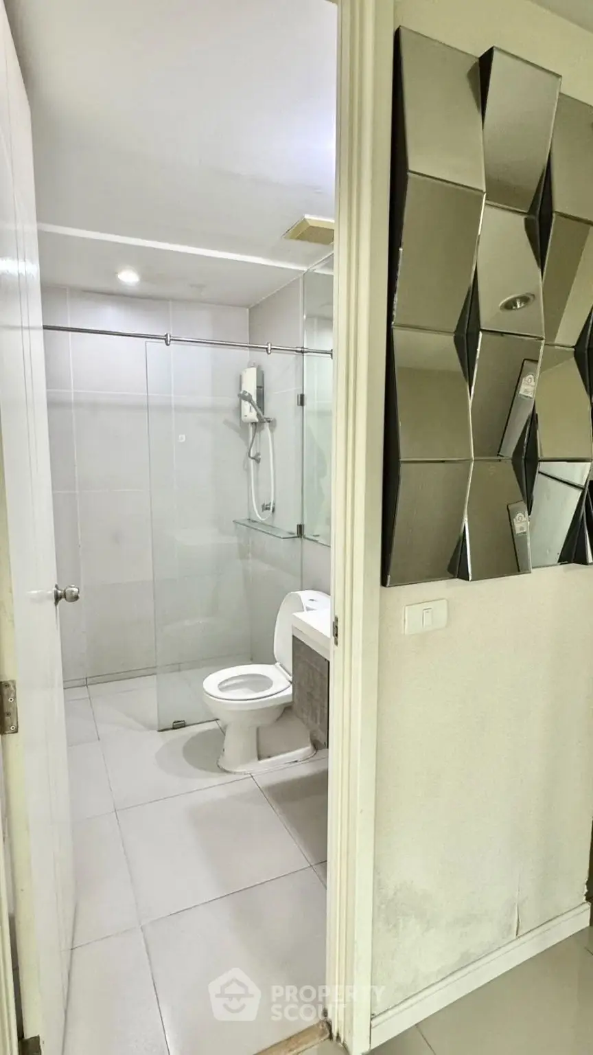 Modern bathroom with glass shower enclosure and stylish wall mirror design.
