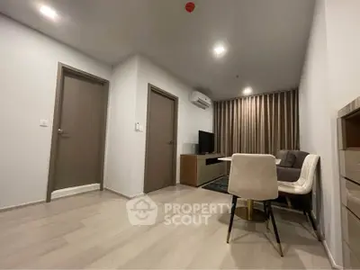 Modern living room with sleek furniture and neutral tones, featuring a cozy sofa and dining area.