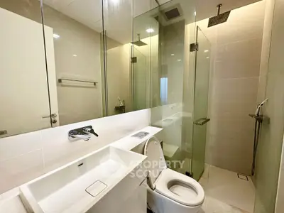 Modern bathroom with glass shower and sleek fixtures in a contemporary apartment.