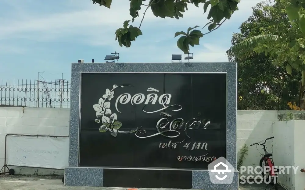 Entrance sign of a residential property with decorative floral design.