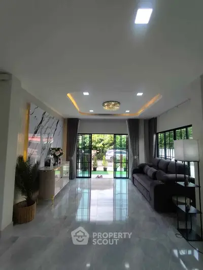 Spacious modern living room with elegant decor and large windows overlooking a lush garden.