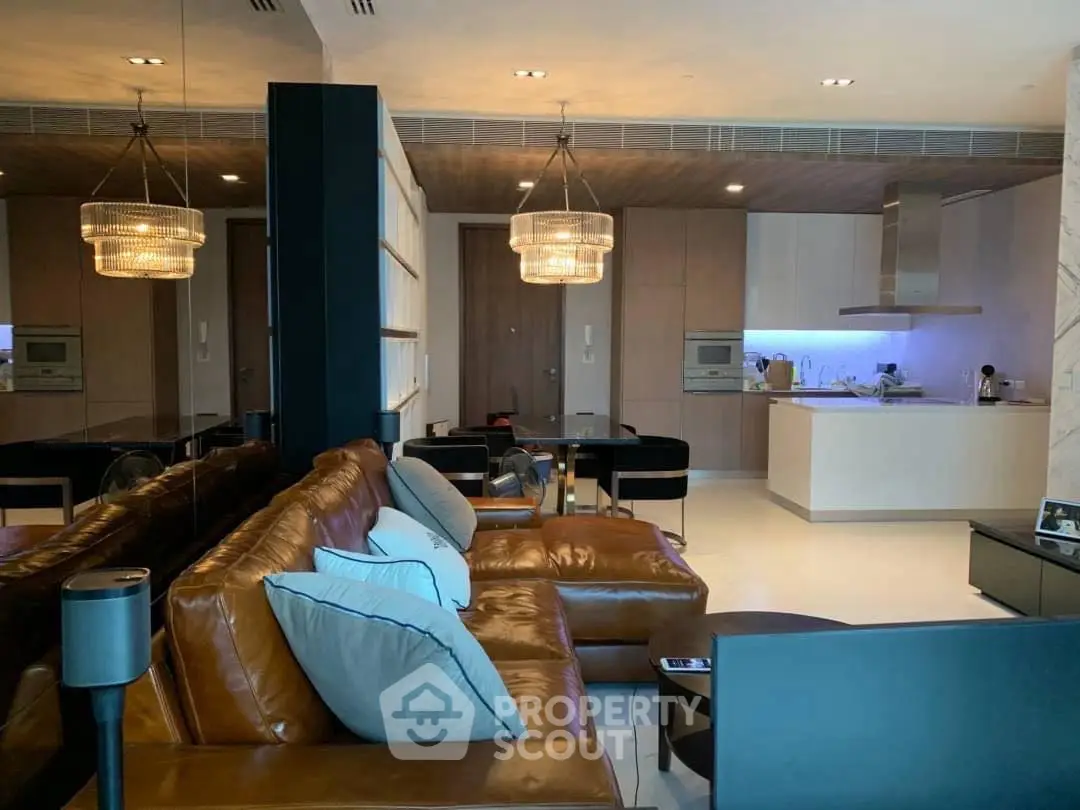 Luxurious open-plan living room with modern kitchen and elegant lighting in a high-end apartment.
