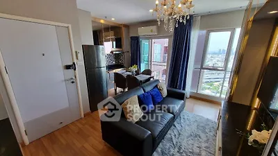 Modern living room with city view, elegant chandelier, and cozy seating area in a high-rise apartment.