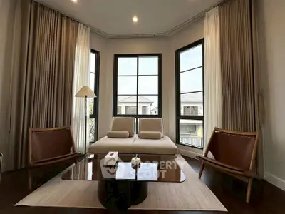 Modern living room with elegant furniture and large windows offering natural light.