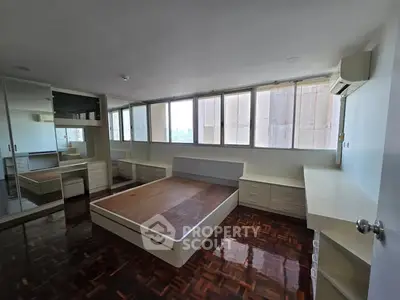 Spacious bedroom with built-in storage and large windows for natural light.