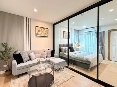 Modern open-layout living room with glass partition to bedroom, featuring stylish decor and cozy ambiance.