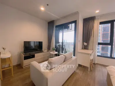 Modern living room with balcony view, featuring sleek furniture and natural light.