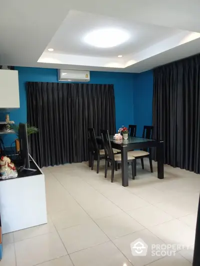 Modern dining room with sleek black furniture and blue accent wall