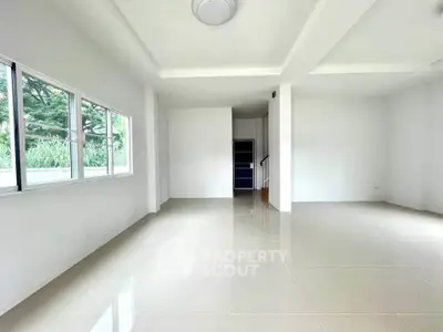 Spacious empty living room with large windows and glossy tiled floors