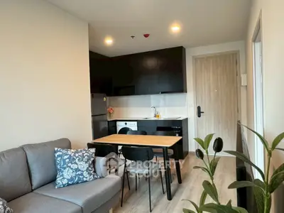 Modern open-plan living room with kitchen, stylish decor, and cozy seating area.