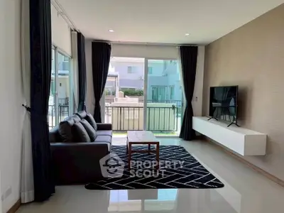 Modern living room with sleek furniture and large windows offering natural light.