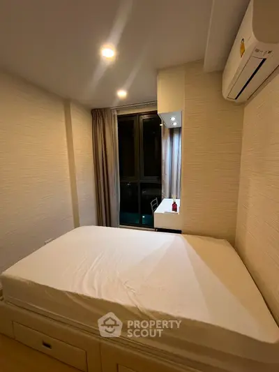 Cozy bedroom with modern air conditioning and ample natural light, perfect for relaxation and comfort.